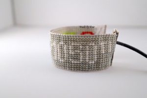 A silver bracelet on the loom